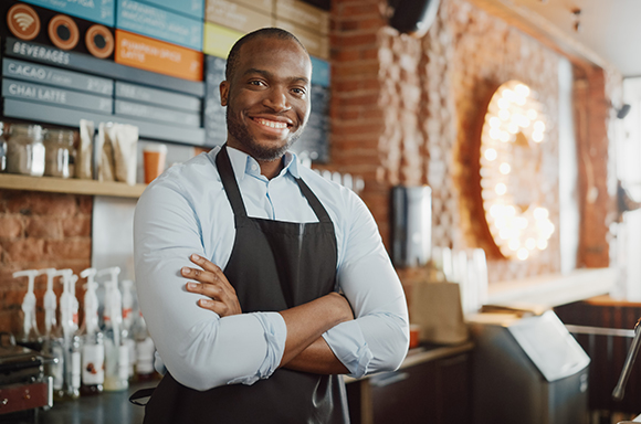 Man with an apron and blue shirt sporting small business insurance in bristol